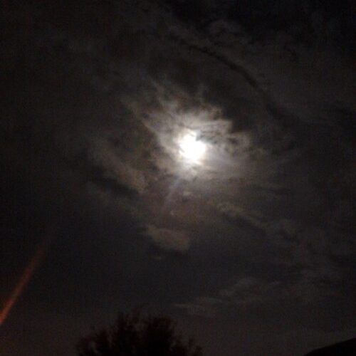 Cloudy night sky with bright full moon.