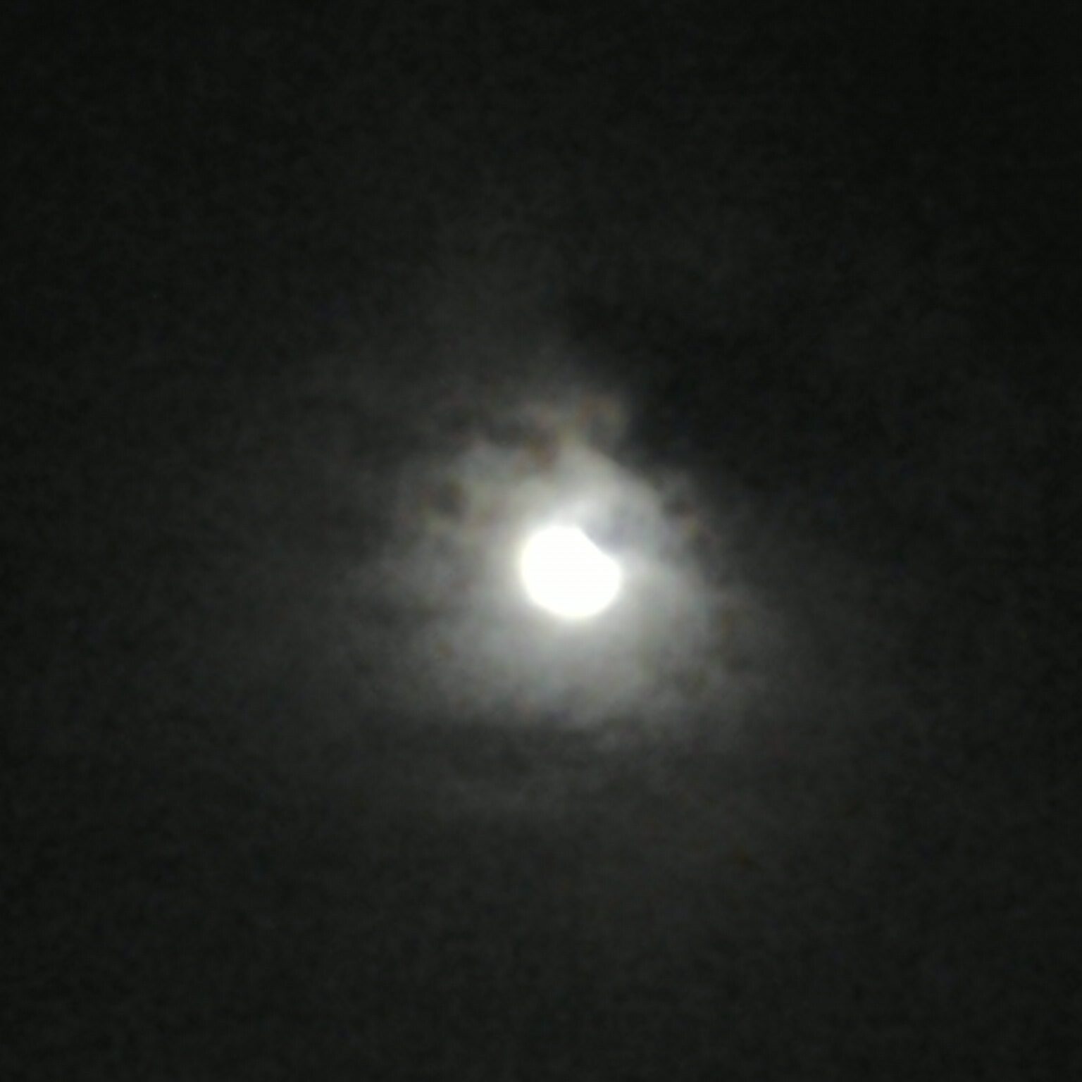 Cloudy night sky with partial moon.