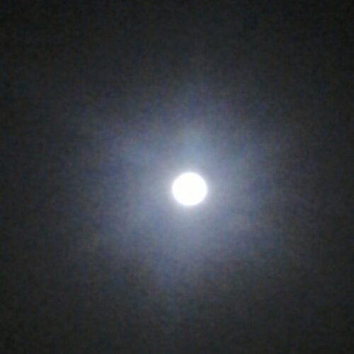 Bright full moon in night sky.