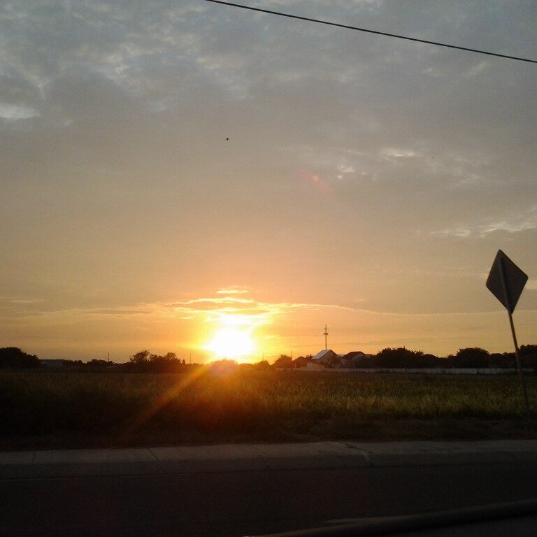 Sunset over a rural landscape with sign.