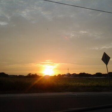 Sunset over a rural landscape with sign.