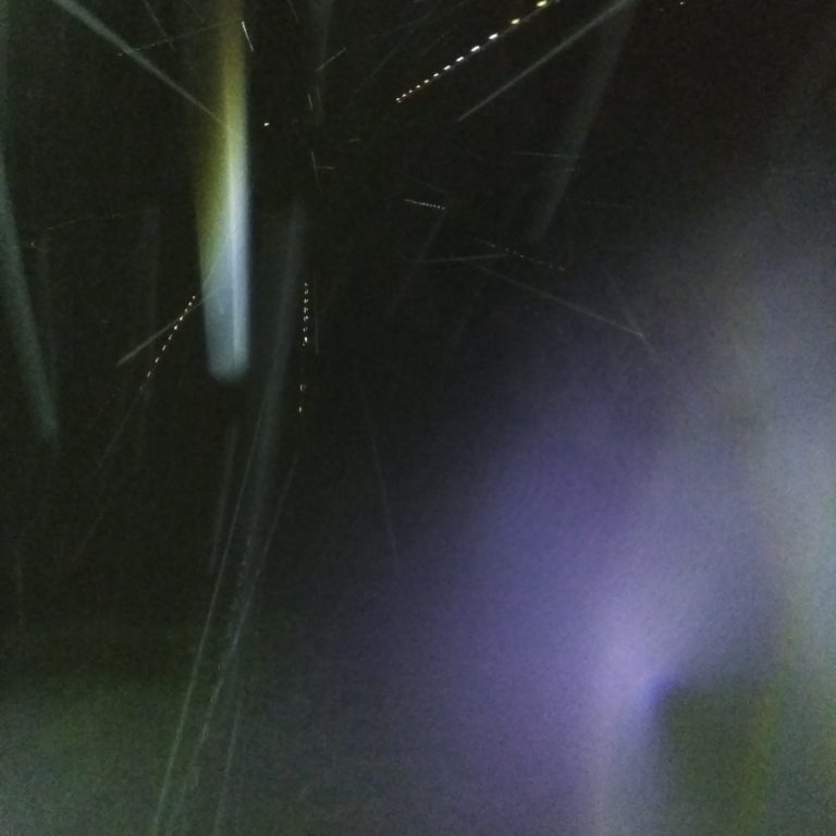 Bright light streaks in dark night sky.