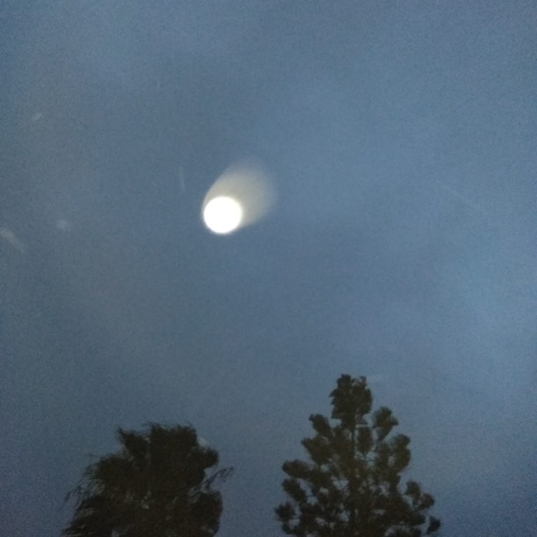 Bright moon in cloudy night sky.