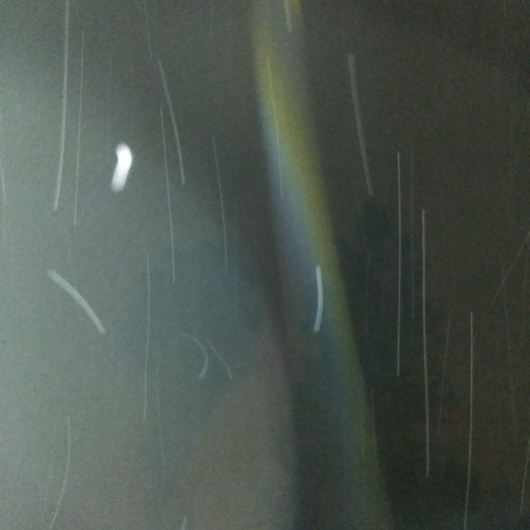 Blurry night sky with light streaks.