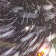 Blurry snowstorm at night with lights.