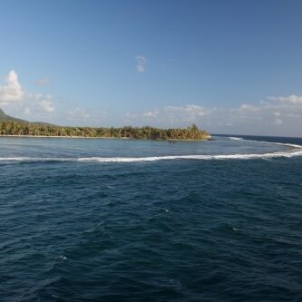 Coastal landscape with ocean and distant hills.