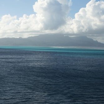 Ocean view with distant cloudy mountains.
