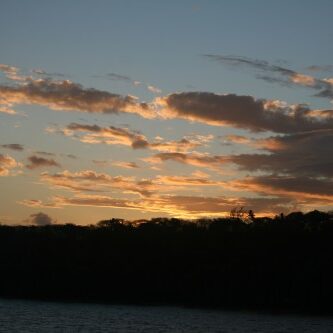 Sunset with clouds over a dark horizon.
