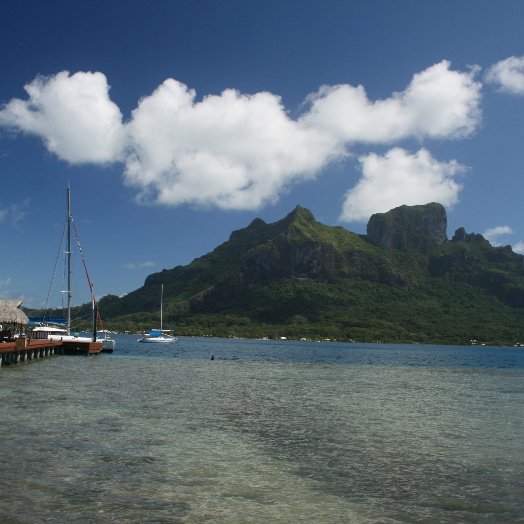Tropical island with dock and mountain view.