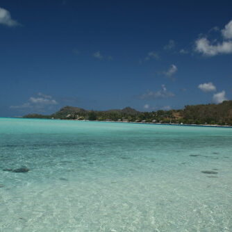 Clear turquoise sea under bright blue sky.