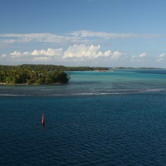 Small island surrounded by blue ocean waters.