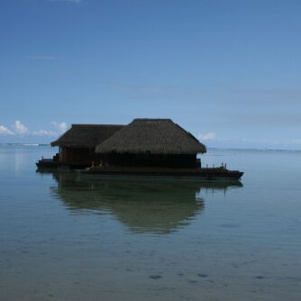 Overwater bungalows on calm, clear water.