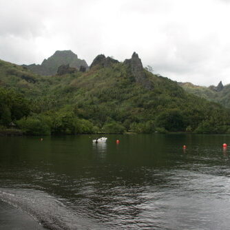 Tropical lake with mountains and cloudy sky.