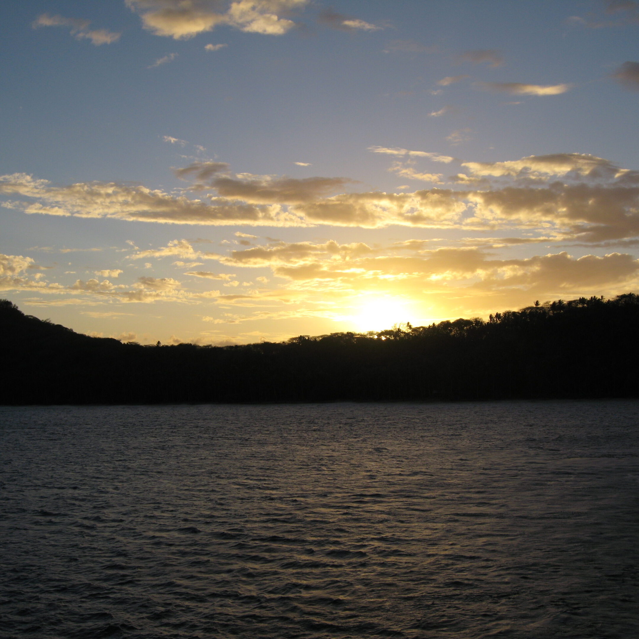 Sunset over a calm, darkened lake.