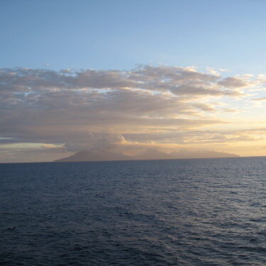 Ocean view with distant island and clouds.