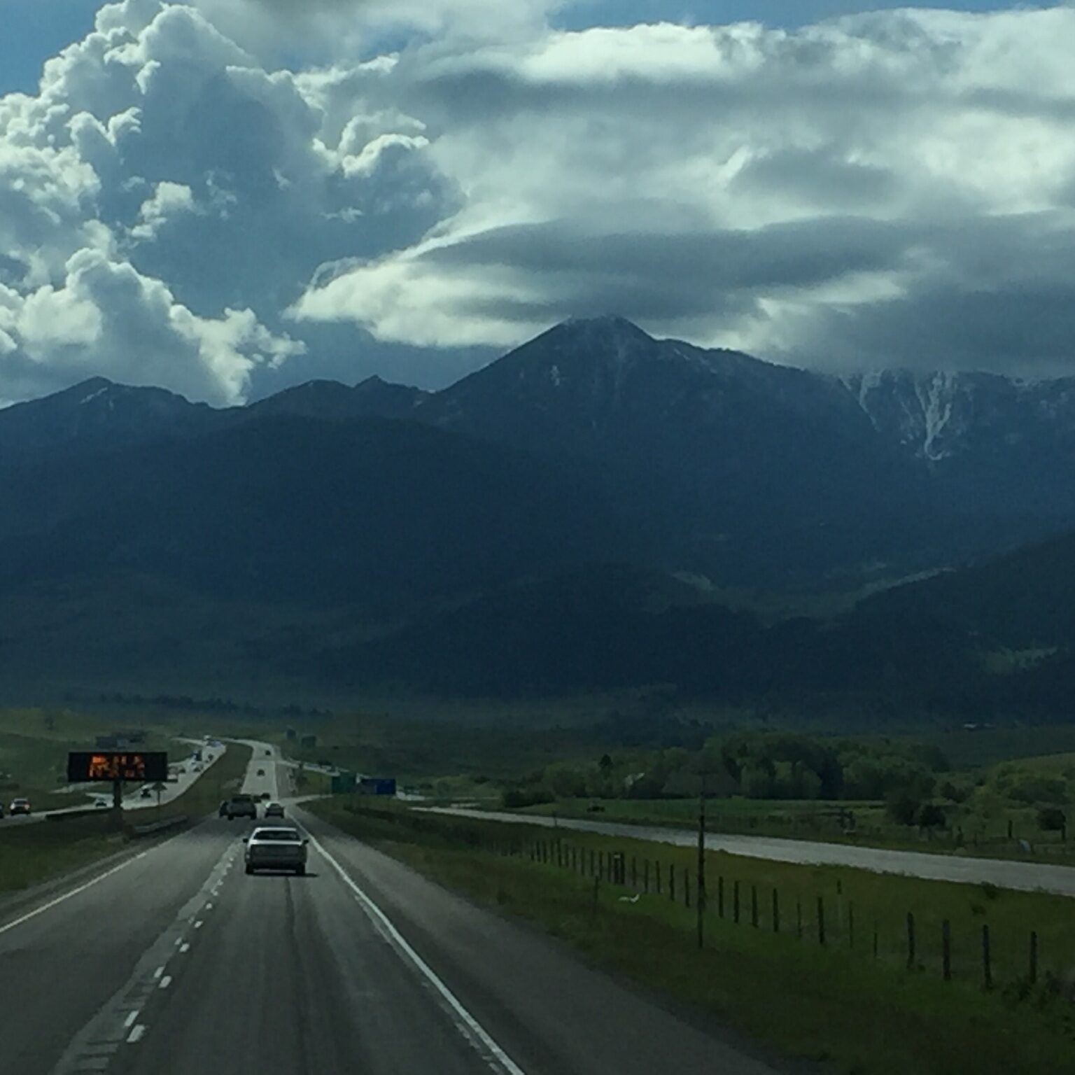 Mountain highway under cloudy sky.