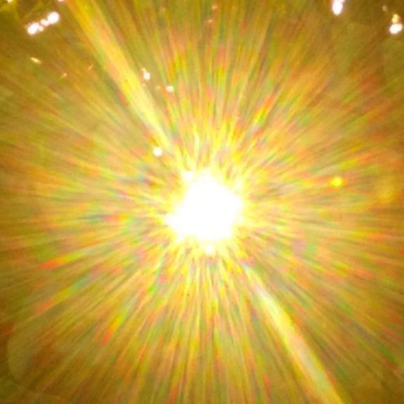 Bright sunburst through leafy branches.