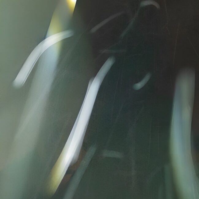 Abstract motion-blurred green light streaks on dark