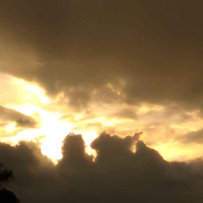 Sunset with dramatic clouds and silhouetted trees.