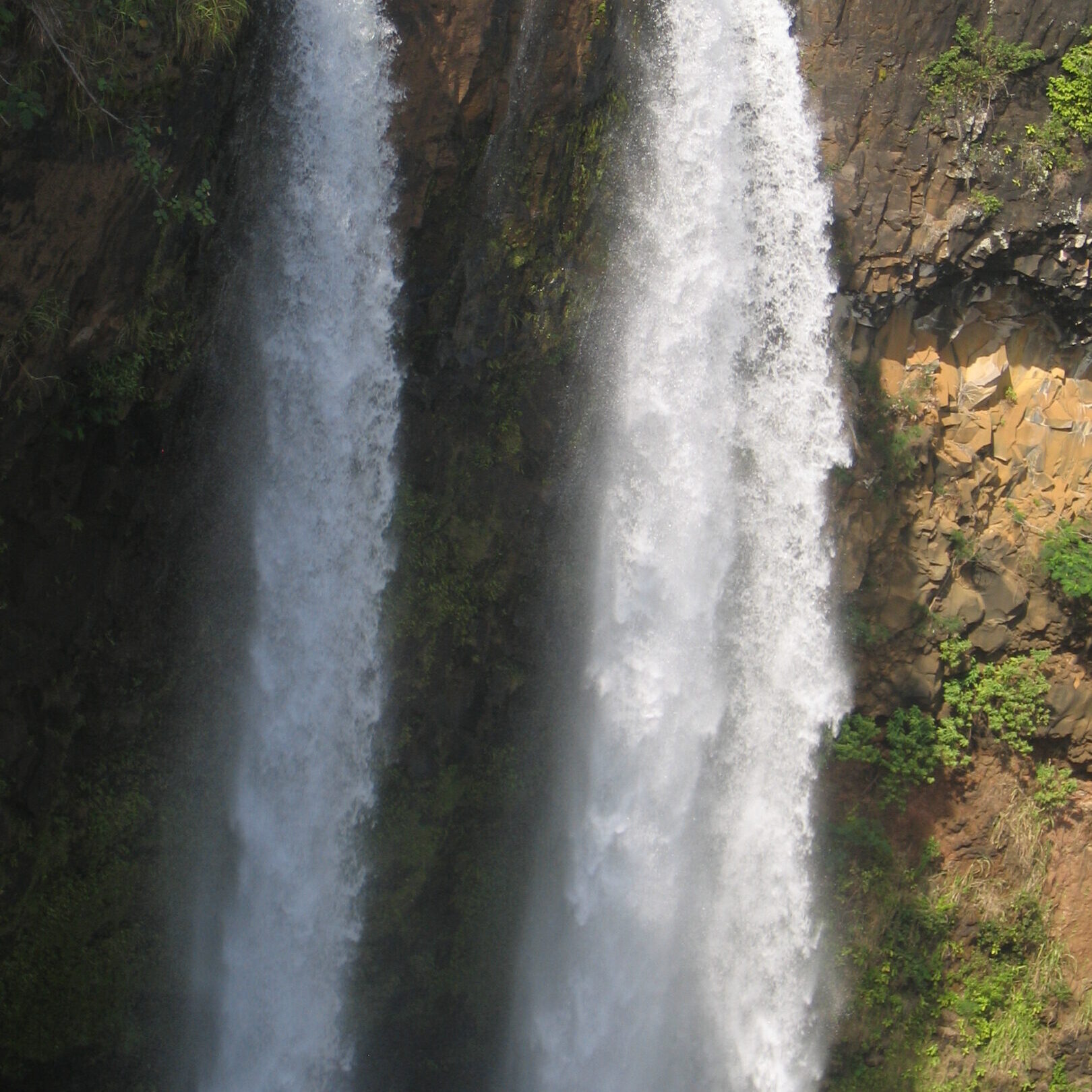 Twin waterfalls cascading over rocky cliffs.